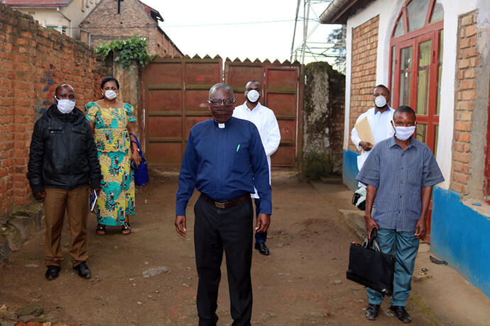 The Rev. Clément Kingombe Lutala (center), Dr. Damas Lushima (back center) and several United Methodist lay leaders wear masks and observe safety protocols in front of Ibanda United Methodist Church in South Kivu, Congo, amid a deadly Ebola outbreak in the region. Bishop Antoine Tambwe Kalema is calling all parishes to implement mandatory preventive measures to curb the spread of the virus. Photo by Philippe Kituka Lolonga, UM News.