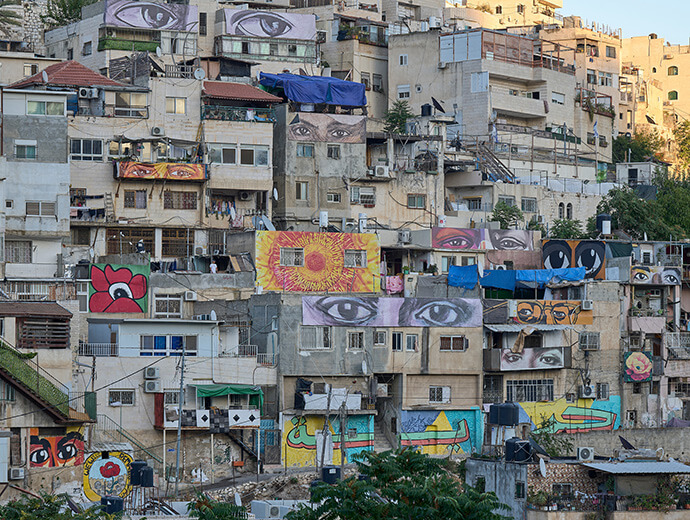 Murals depicting the eyes of local and international leaders, activists and others are painted on Palestinian homes in Silwan, a neighborhood of occupied East Jerusalem. Like nearby Wadi Foquin, Silwan faces destruction under the proposed Jerusalem Metropolitan Bill. File photo by Paul Jeffrey.