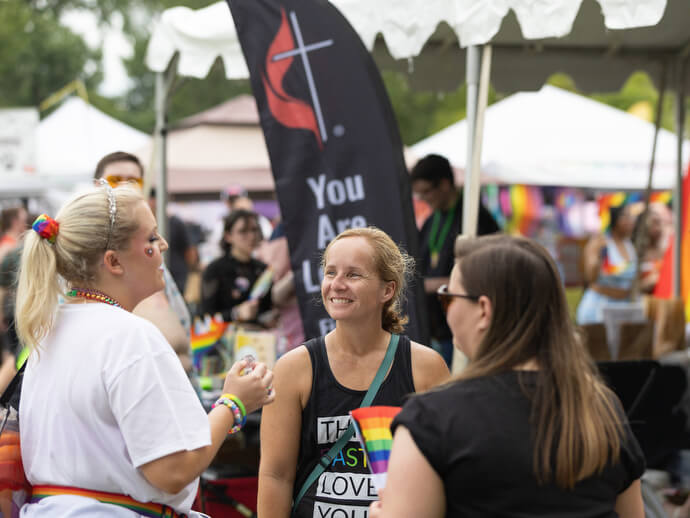The Rev. Stephanie Dodge (center) greets visitors to the United Methodist booth at the Nashville Pride Festival. Dodge is pastor of Glendale United Methodist Church.