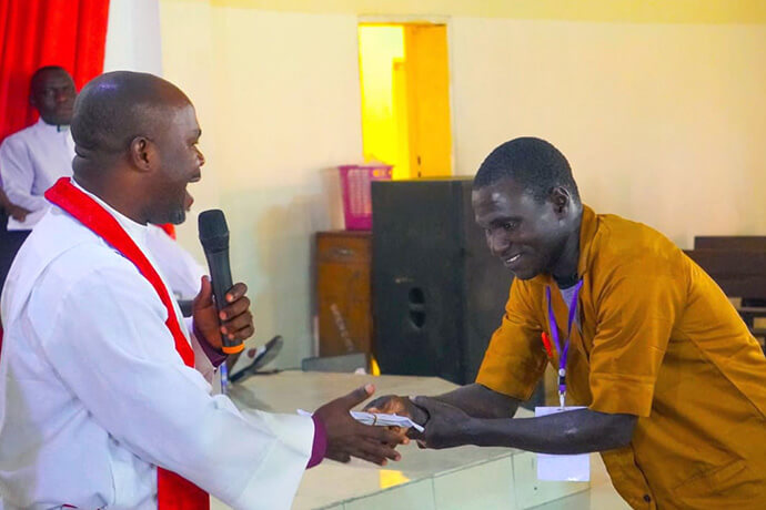 Bishop Ande I. Emmanuel (left) presents an envelope containing grant money to Henry Ngai, director of The United Methodist Church’s Technical Training Program, to be distributed to students during a graduation ceremony in Jalingo, Nigeria. Each participant who completed the training received 100,000 naira (approximately $73 USD) to help launch their own businesses. Photo by Joseph Dauda Idris, UM News. 