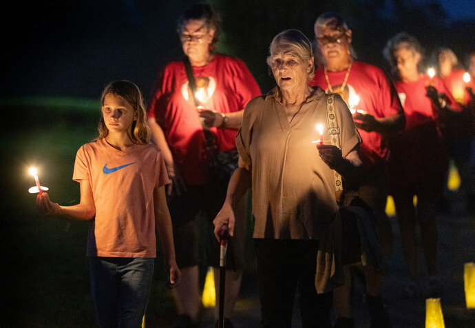 Sophie Keeton (left) and her great-grandmother, Gayle Barber, join in a service of remembrance for missing and murdered Indigenous people during the Native Moccasins Rock gathering. 