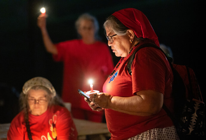 Loretta Bolden (right), a member of the Eastern Band of Cherokee Indians, offers a prayer during a service of remembrance for missing and murdered Indigenous people during the Native Moccasins Rock gathering. 