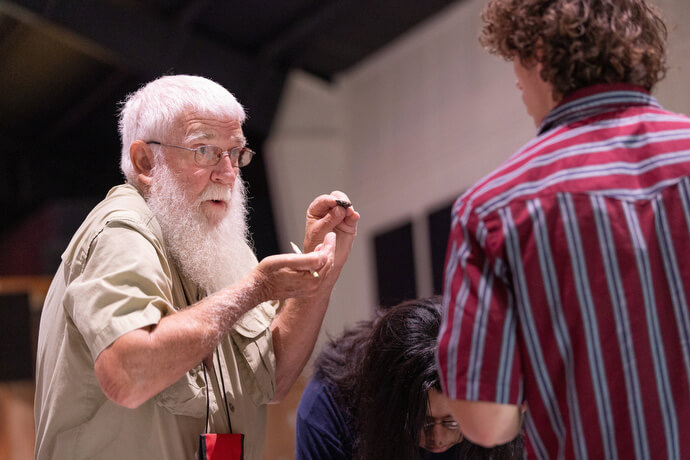 Buddy Hayes (left) leads a workshop on flintknapping, used to make arrowheads, spear points and other stone tools, during Native Moccasins Rock. 