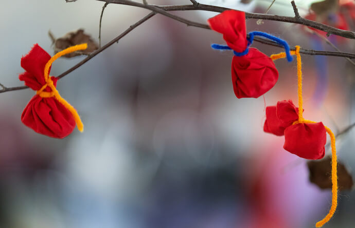 Prayer bundles containing sacred tobacco hang from a branch at Native Moccasins Rock, a gathering celebrating Native culture and spirituality at Camp Lake Benson in Bon Aqua, Tenn. The bundles are physical manifestations of personal prayers and gratitude. 