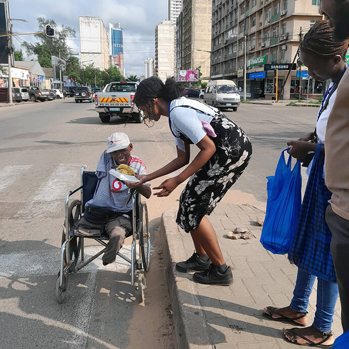 Rute Gomes, jovem metodista unida e directora dos assuntos sociais no distrito de Maputo Sul, partilha uma refeição com um irmão necessitado. Foto de Silvania Mucale. 