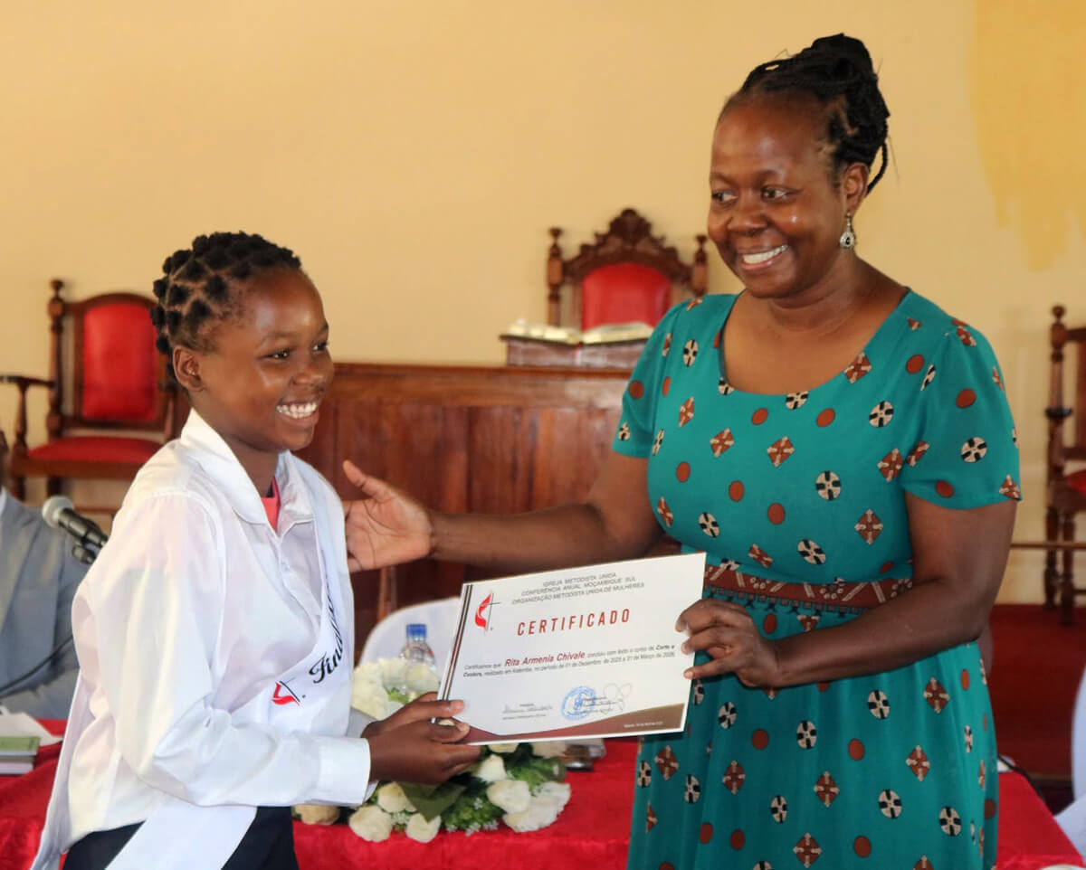 Coordenadora Regional Angelina Mbulo oferecendo o certificado a jovem graduada no curso de corte e Costura em Katembe - Maputo- Foto de Roque Facela. 