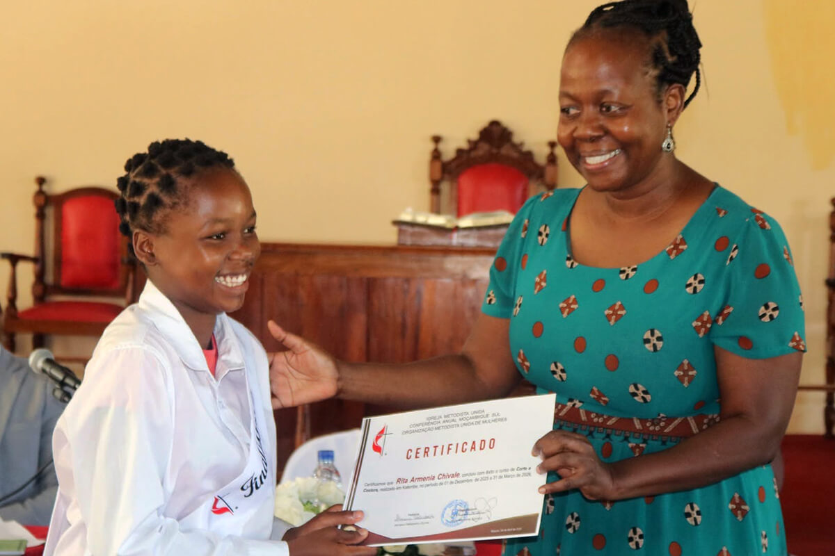 Coordenadora Regional Angelina Mbulo oferecendo o certificado a jovem graduada no curso de corte e Costura em Katembe - Maputo- Foto de Roque Facela. 