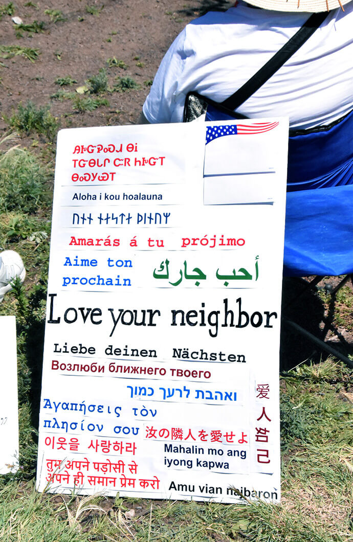 A sign used by churchgoers at the Delaney Hall immigration detention center in Newark, N.J., says “Love your neighbor” in multiple languages. Photo by John W. Coleman, UM News. 