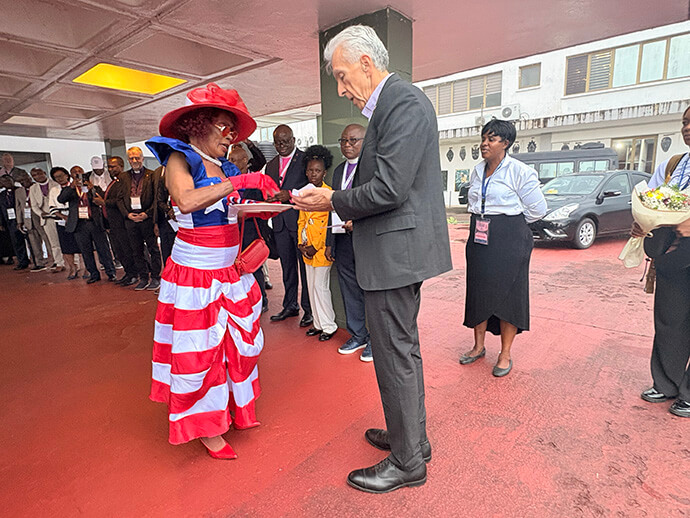 “Mama Liberia” welcomes Bishop Rubén Saenz Jr., Council of Bishops president, upon his arrival at the Roberts International airport in Margibi County, Liberia. The Liberian icon presented him with kola nuts and a scarf in the Liberia national colors. Photo by Eveline Chikwanah, UM News.