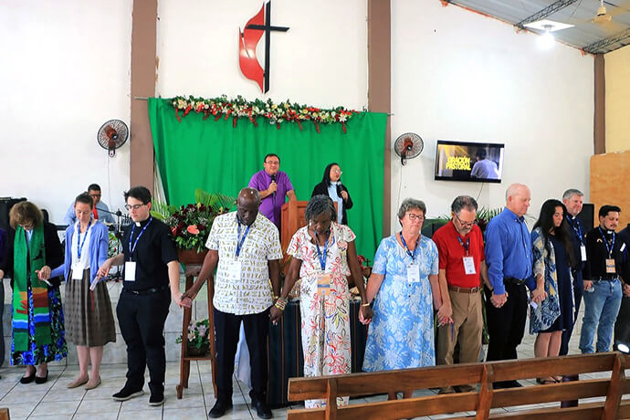 Bishop Juan de Dios Peña leads a prayer of thanksgiving for the presence of delegates attending the World Methodist Council meeting at the Evangelical Methodist Church of Ahuachapán in San Salvador. “The presence and participation of Methodist leaders from different parts of the world in local Salvadoran churches has been a powerful encouragement for local pastors and leaders,” Peña said. Photo courtesy of the Evangelical Methodist Church of El Salvador.
