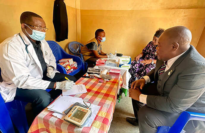 Dr. Élisée Kilumba speaks with Shenda Shuku Jean during a free healthcare campaign held in Kalemie, Congo. The lay vice-leader of the Kalemie District and evangelistic pastor in Tembo received treatment for pain related to high blood pressure, a consultation that would have cost him more than 200,000 Congolese francs at a public hospital. Photo by Chadrack Tambwe Londe, UM News.