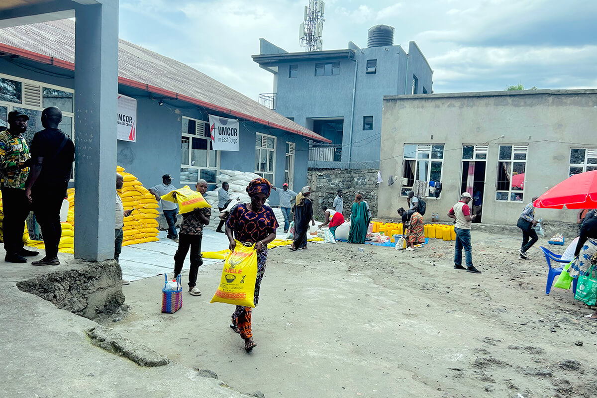 Des bénéficiaires et des membres de l’Église se rassemblent devant l’église locale d’Amani à Goma, au Congo, avant le début d’une distribution mensuelle de vivres organisée par le Bureau de gestion des catastrophes du Comité Méthodiste Uni de secours (UMCOR) dans la Région épiscopale de l’Est du Congo. Cette initiative vise à rendre dignité et stabilité aux familles déplacées et fragilisées par l’insécurité et la hausse du coût de la vie dans la région. Photo : Jolie Shabani Mulebinge, UM News.