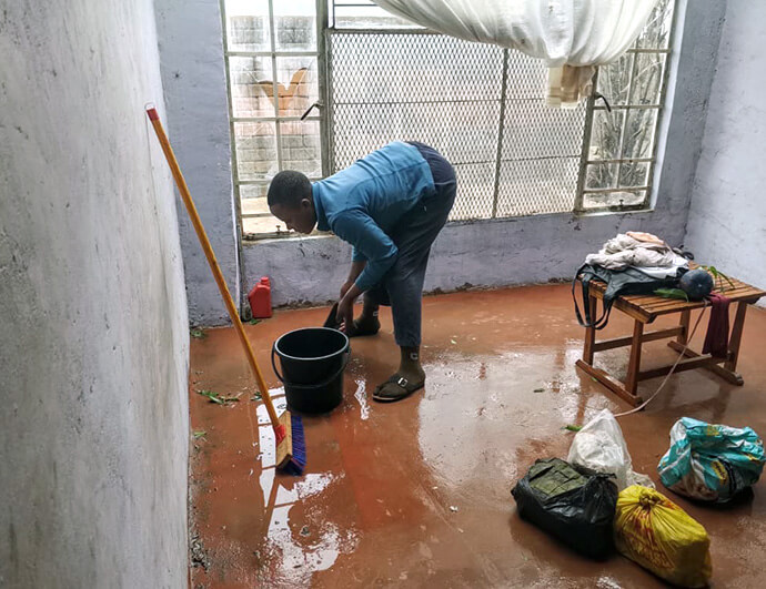 Tinashe Timere mops water that flooded the family home during the Oct. 5 storm.  The heavy rain and hailstones destroyed windows, roofs, furniture and other goods leaving some families homeless. Photo by Pastor Samuel Maunga, UM News.