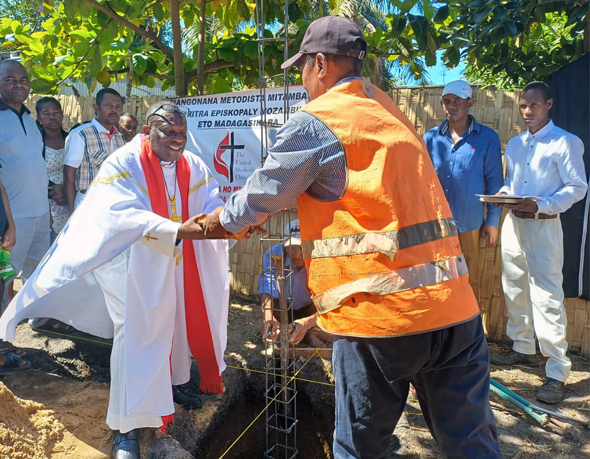 The Rev. Eric Kalumba Nkulu, a Global Ministries missionary assigned as a church planter in Madagascar, receives the first stone of a new United Methodist church building from a local construction worker in Sambava, Madagascar. The church will be home to a growing congregation in the northern part of the country. Photo by Rosette Viviane, UM News.