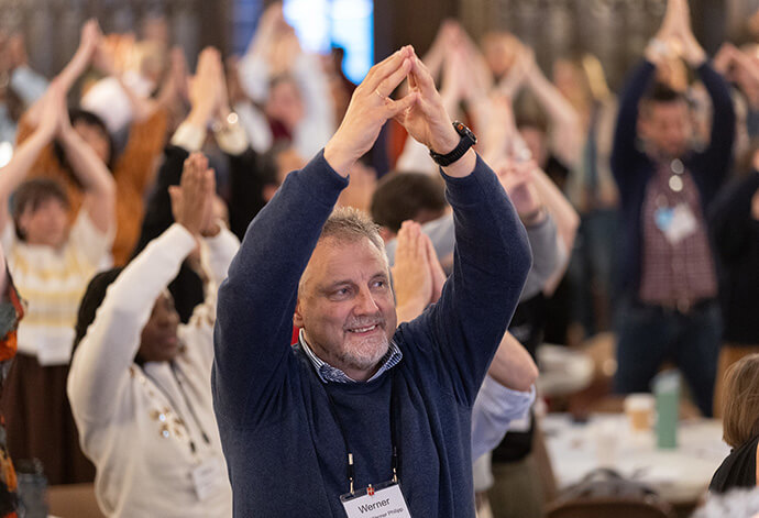 Bishop Werner Philipp of Germany joins in a stretching break during the United Methodist Leadership Gathering at Knox United Church in Calgary, Canada, on Oct. 22. Photo by Mike DuBose, UM News.